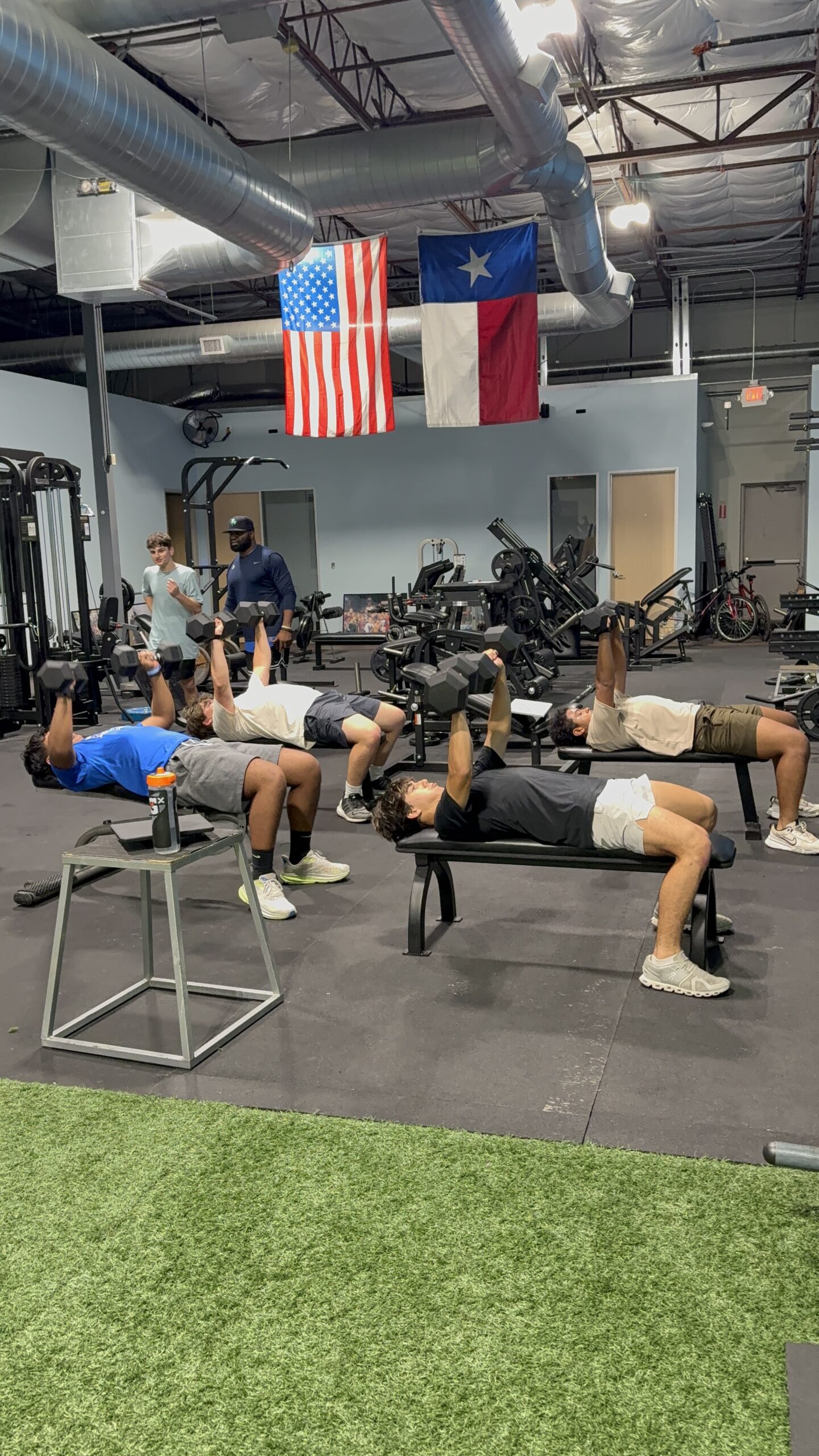 Group bench press workout in gym setting.