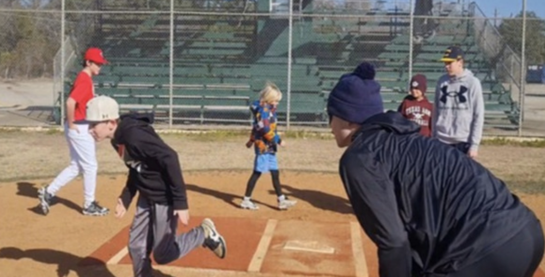 Children playing baseball on a sunny field.
